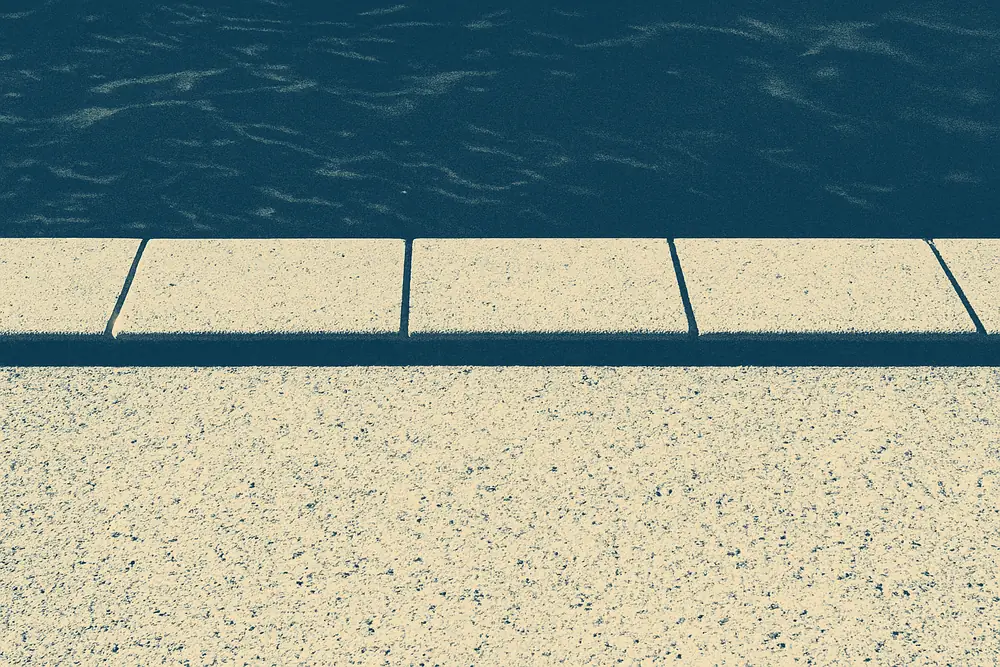 A close view of pool edge tiles and the join with the surface below — pool resurfacing quotes and contracts, Ballarat. Illustrative example.